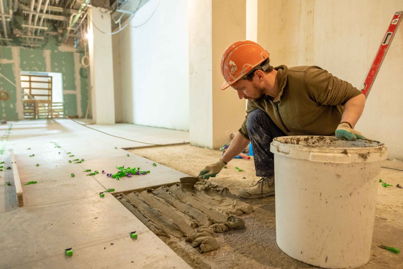 Professional installer laying floor tiles during a renovation